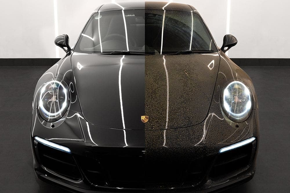 Black Porsche 911 showing a clean, protected finish beside an untreated section